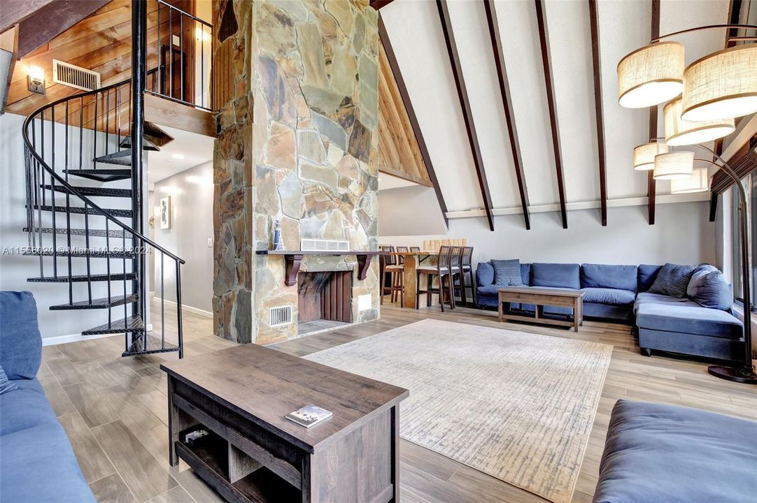 At the heart of this retreat lies a stunning flagstone style fireplace, an art piece in its own right. Its natural stone facade, rich in hues and texture, radiates a cozy warmth that invites you to unwind and relax.