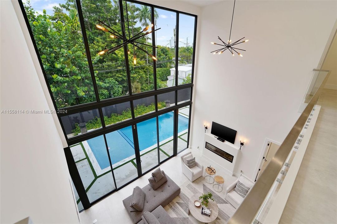Soaring ceilings with views into the living room and pool deck