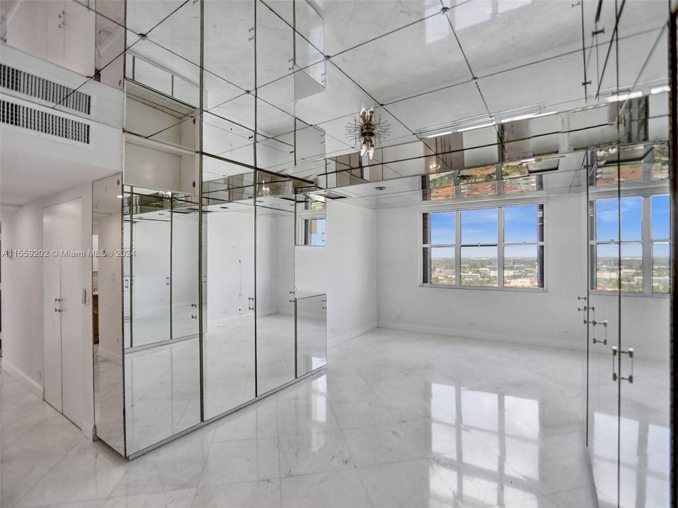 Marble floors along with the mirrors bring so much light into this primary room and all through the condo!