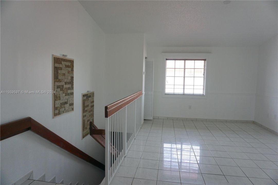 Photo of living room looking from kitchen with stairs leading outdoor