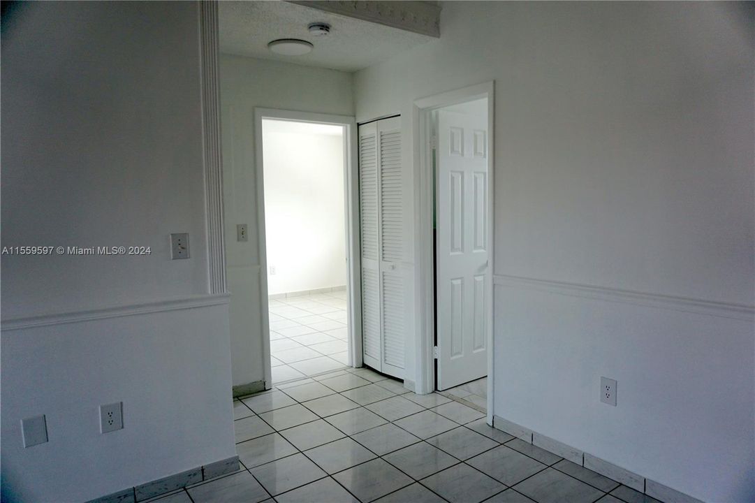 Hallway leading from dining area to guest bathroom. Linen closet pictured