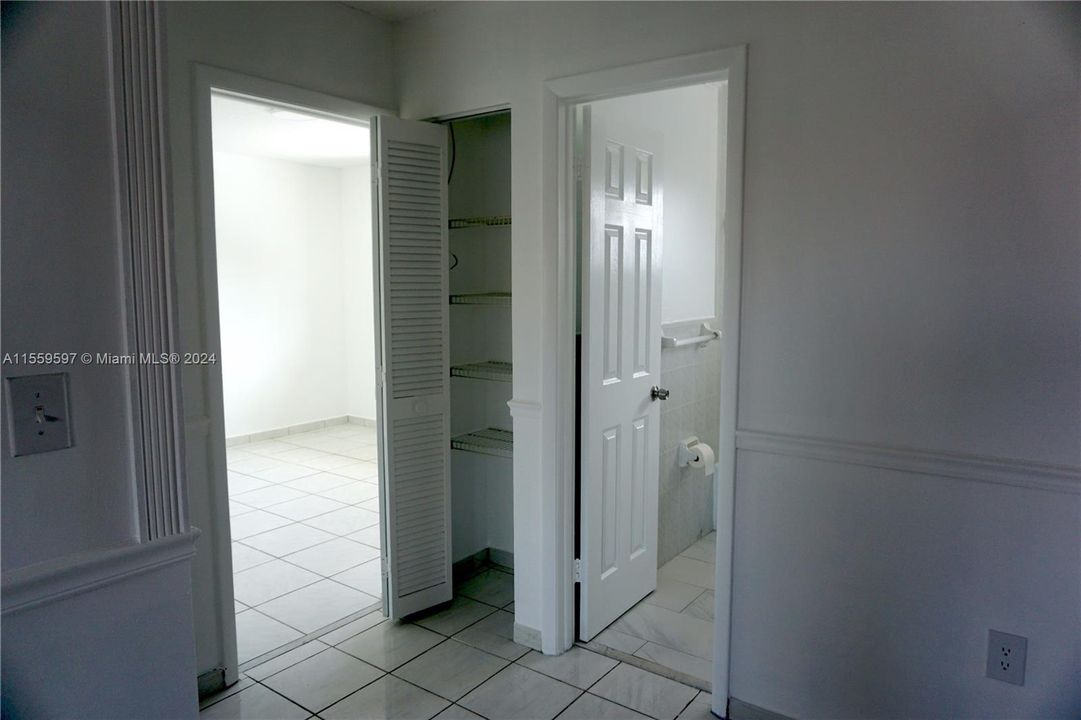 Hallway showing linen closet open. Separates both bedrooms