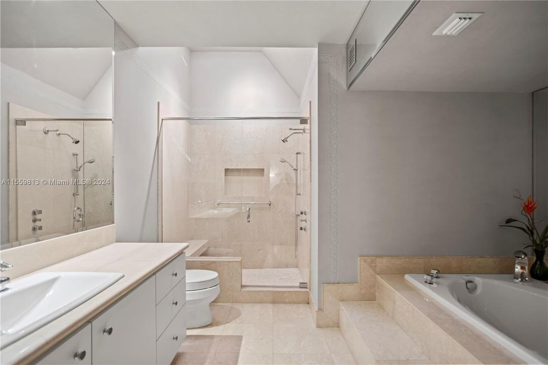 Spacious primary bathroom with huge shower and tub