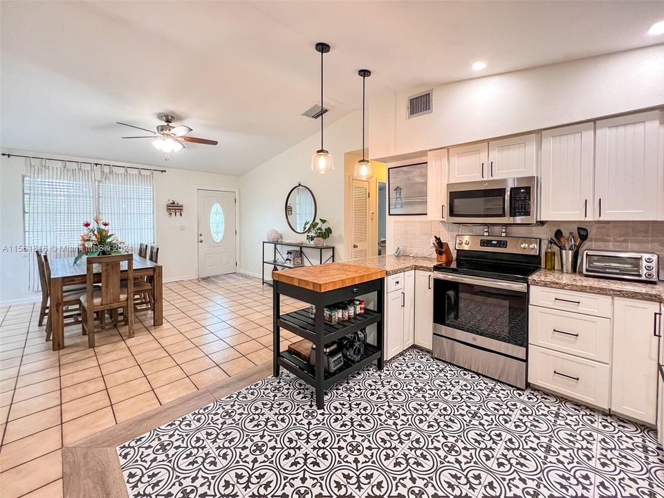 Chic design meets function in this stylish kitchen, featuring a bold tile centerpiece that anchors the room, ready for both meal prep and impromptu gatherings.