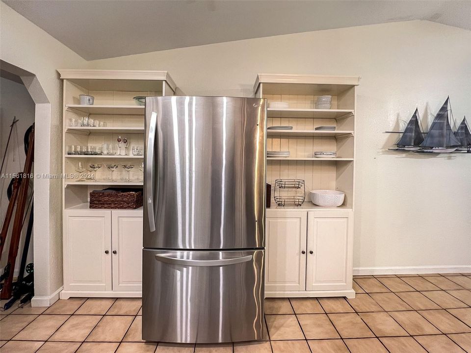 Great kitchen storage surrounding this stainless steal fridge. Perfect for cocktail glasses and extra dishes.