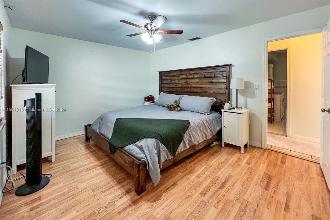 Unwind in this generously sized bedroom that boasts a blend of contemporary comfort and rustic flair, an ideal haven for restful nights and lazy weekend mornings.