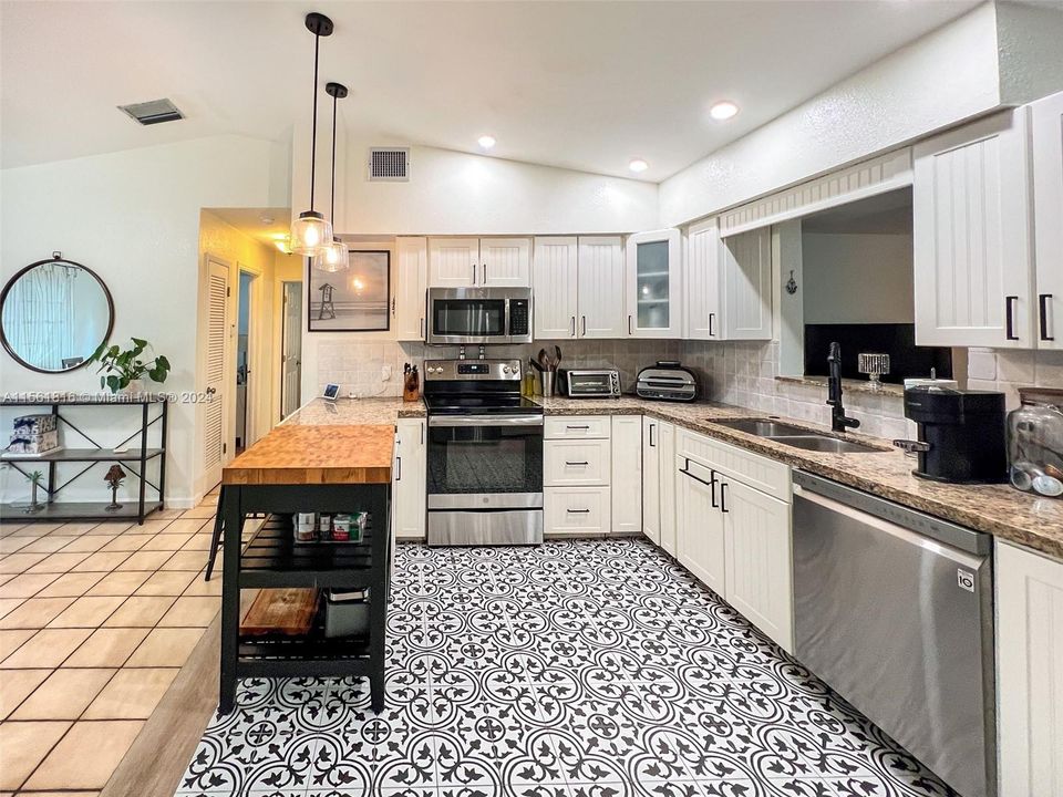 Savor the elegance of this spacious kitchen, boasting eye-catching tile flooring and a sleek design that makes both cooking and hosting a sheer delight