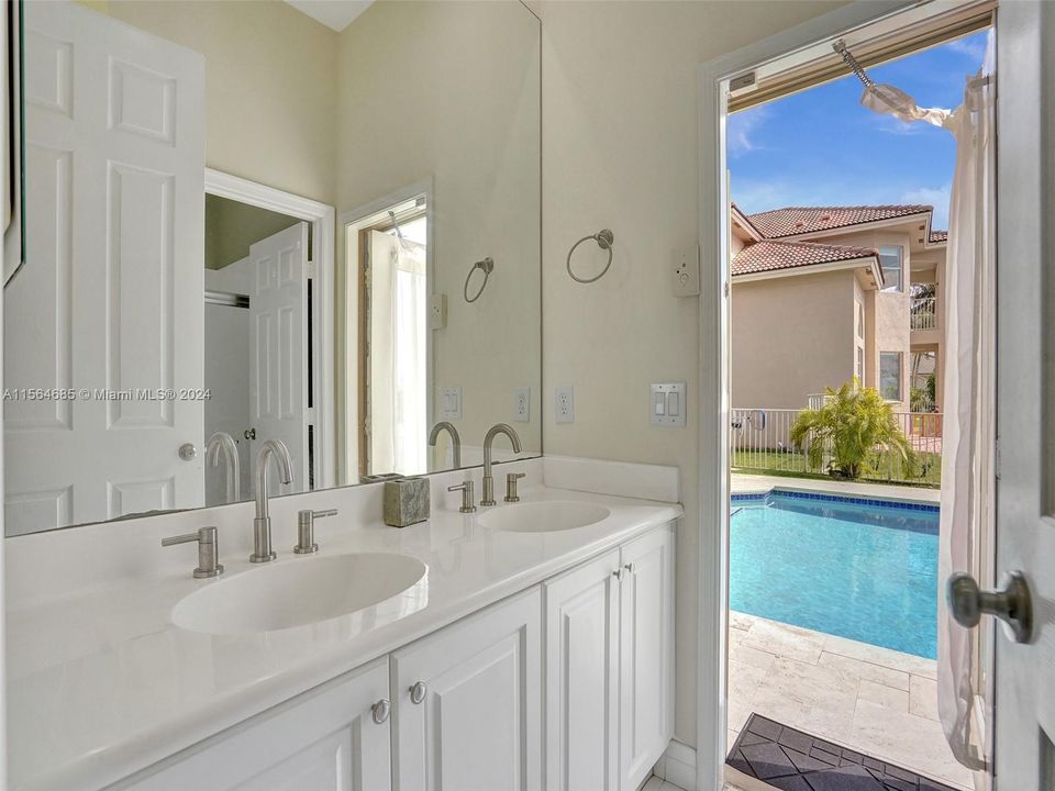 The second en-suite bath doubles as a cabana bath, opening up to the pool area