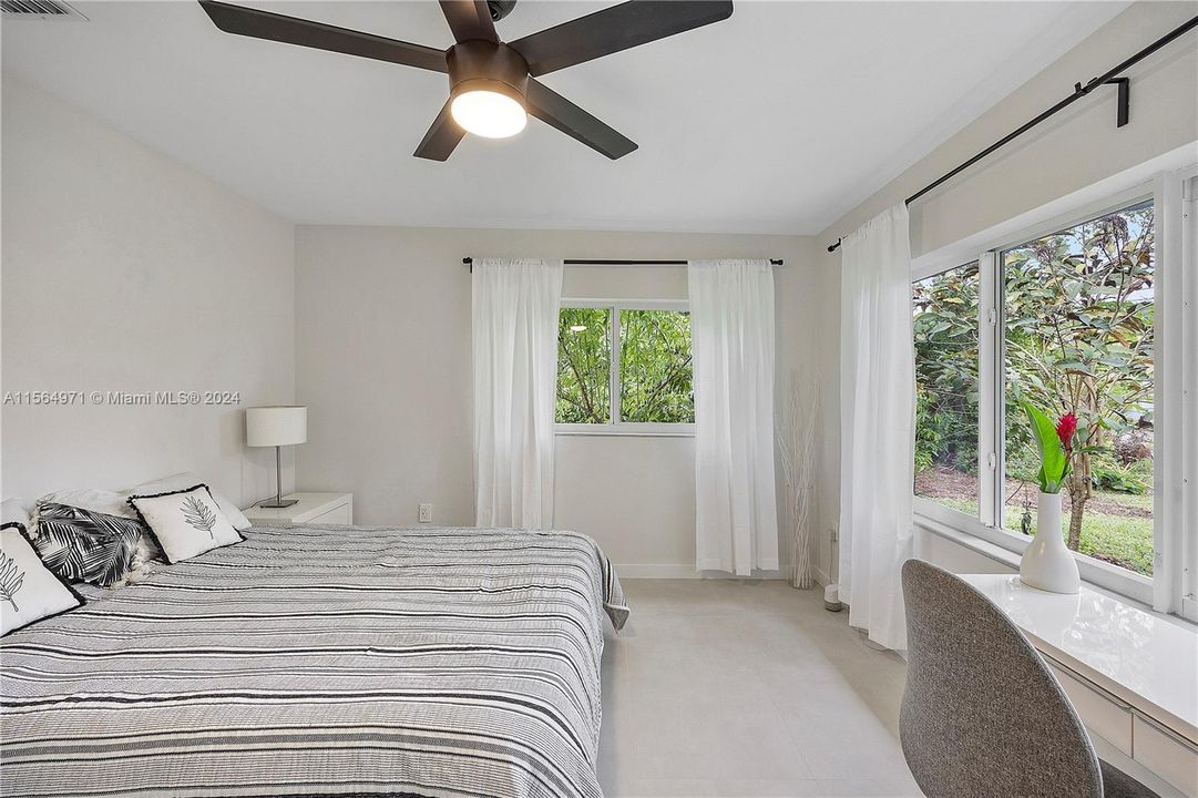 The master bedroom, with stunning garden views and abundant natural light, boasts built-in closets, an external walk-in closet, ample space for a home office.