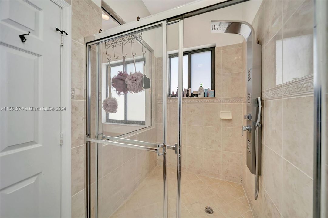 Large stall shower with window to the rest of the bathroom and new shower fixture