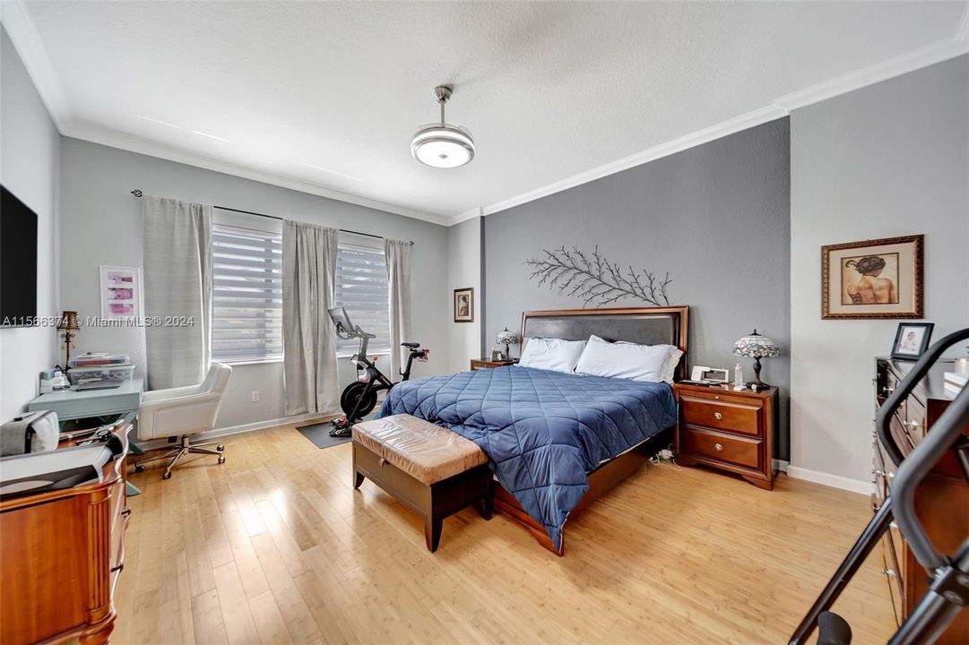 Large Primary Bedroom with bamboo flooring and new modern fan/light fixture