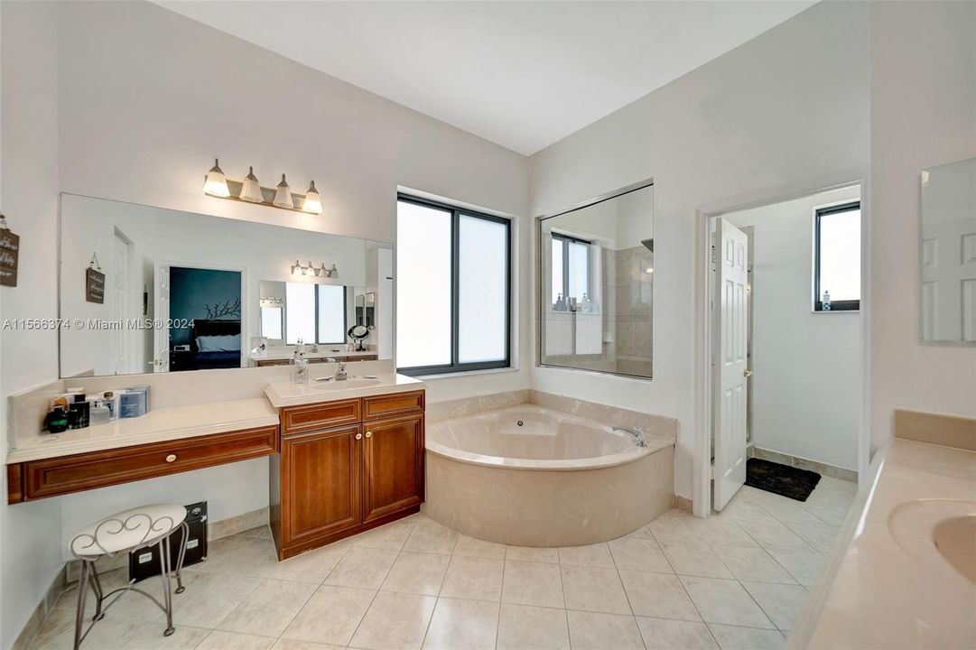 Primary Bathroom with double sink/vanity, large soaking tub, separate commode room and stall shower