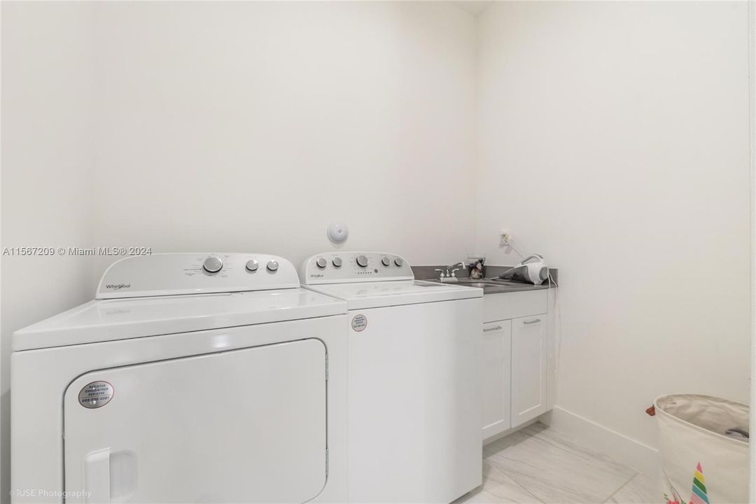 Laundry room with sink and door convenient for cleaning