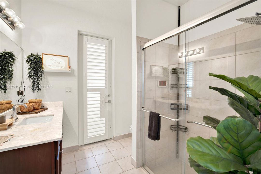 Bathroom accessible from kitchen, bedroom and exterior patio for guests.