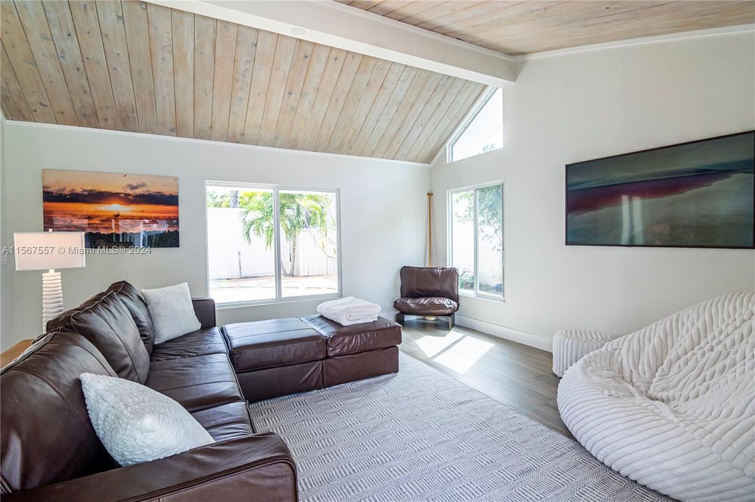 vaulted ceilings with view of gardens and pool