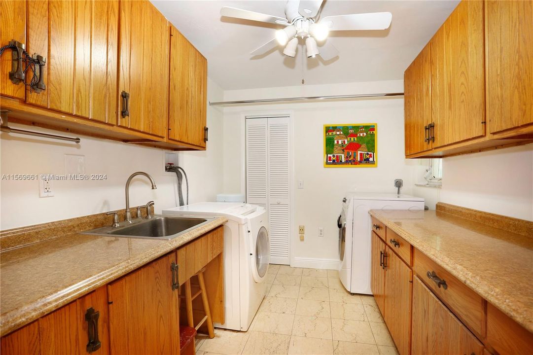 Laundry room with sink and additional cabinetry