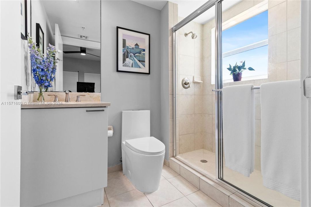 Ensuite Bathroom to Bedroom #3 featuring One-Piece Dual-Flush Toilet, Walk-In Shower with Views of Ocean, Biscayne Bay, Oleta State Park & Miami city skyline.