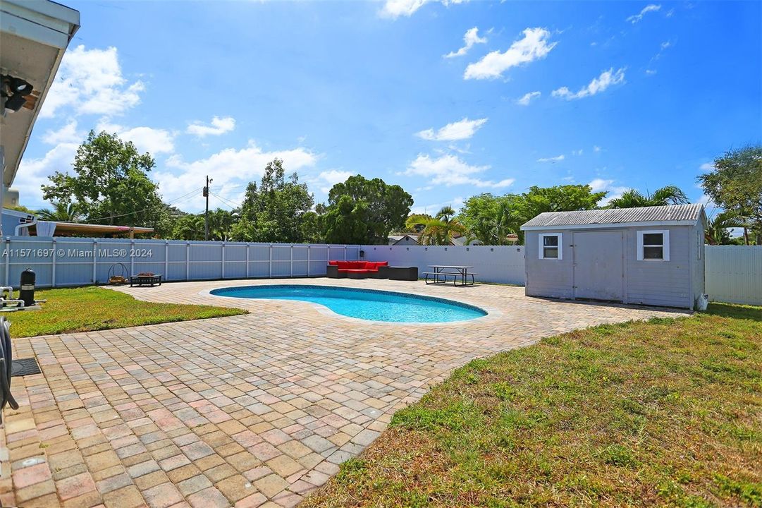 Cobblestone Paved Deck with large Yard Pool and Storage Shed