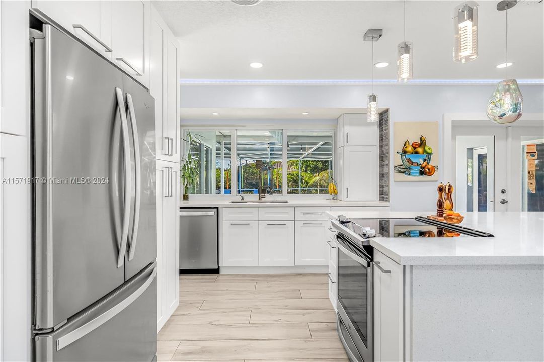 Fully updated Kitchen featuring Soft Close White Cabinetry, Waterfall Quartz Countertops, Stainless Appliances, Tile Backsplash, Recessed And Modern Lighting and so much more!  Kitchen open to the Living area.