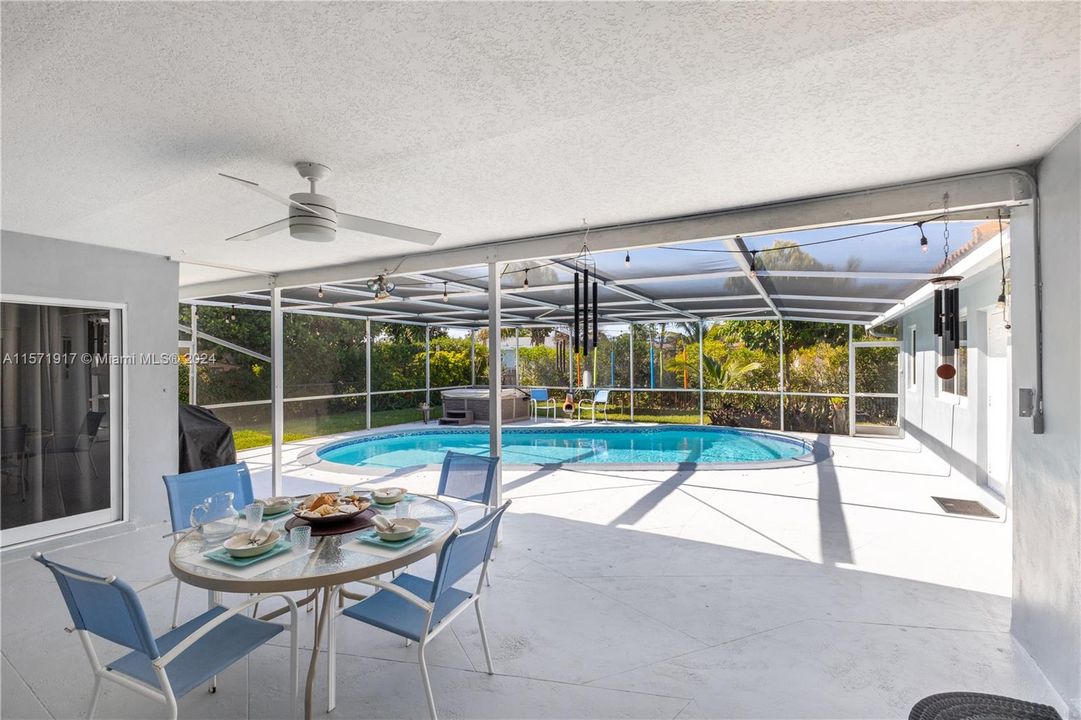 Large covered patio area overlooking the screened-in pool