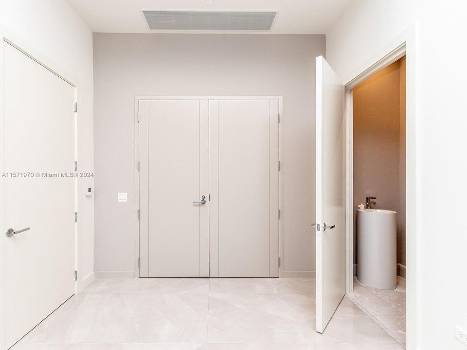 Entrance with large storage and powder room.