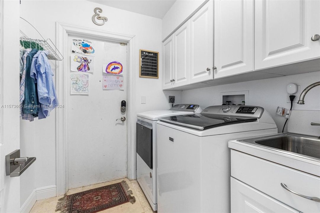 Convenient indoor laundry room with storage and access to 2-car garage