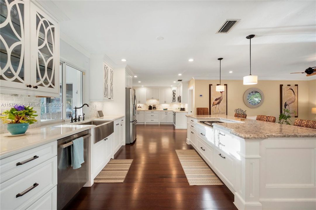 The kitchen features custom wood cabinets, dark bamboo flooring, and upgraded Thermador appliances.