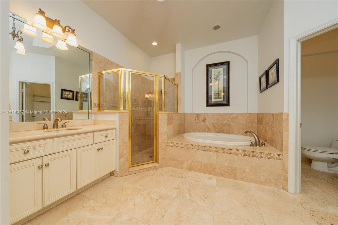 Ensuite bathroom with two vanities, large shower, roman tub and water closet with bidet