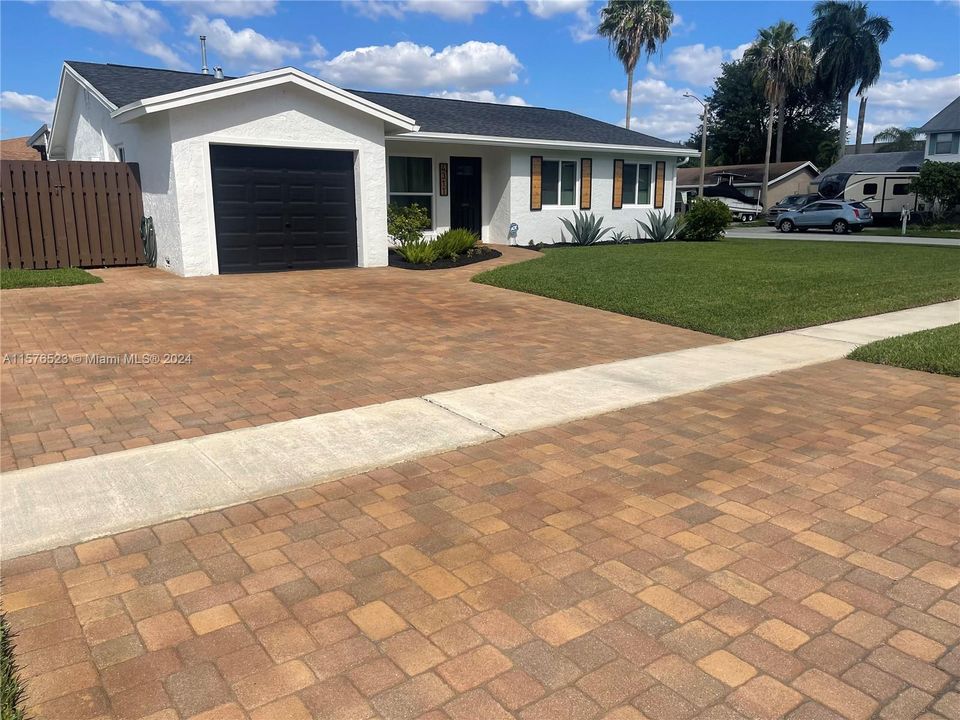 Newly sealed and stained brick paver driveway