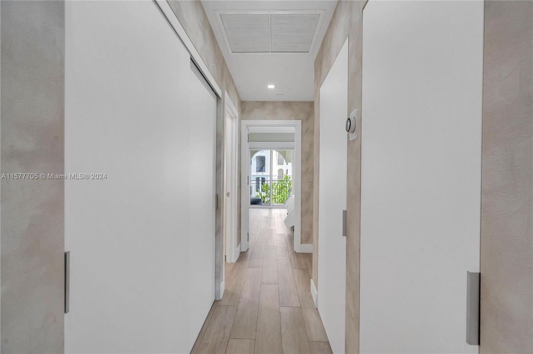 Hallway to guest bedrooms with custom doors.