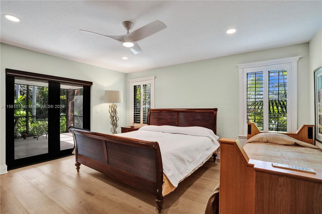 Enter the sanctuary of luxury and tranquility within the master bedroom, where plantation shutters and rich wood floors evoke a timeless elegance