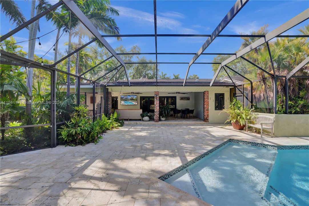 Step into a haven of tranquility and luxury in the backyard oasis, where a screened pool and lush vegetation combine to create an enchanting retreat