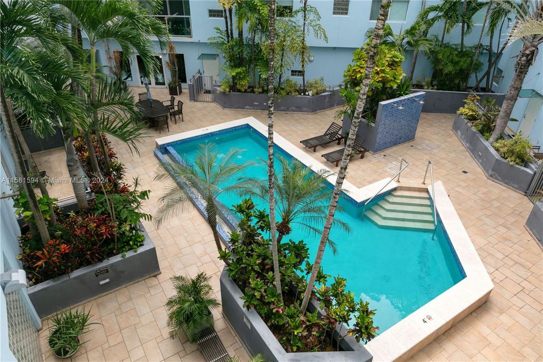 View of pool & outdoor showers from entrance balcony.