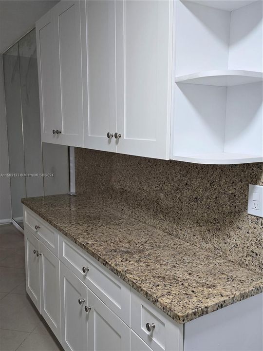 3rd view of kitchen cabinetry and granite counter