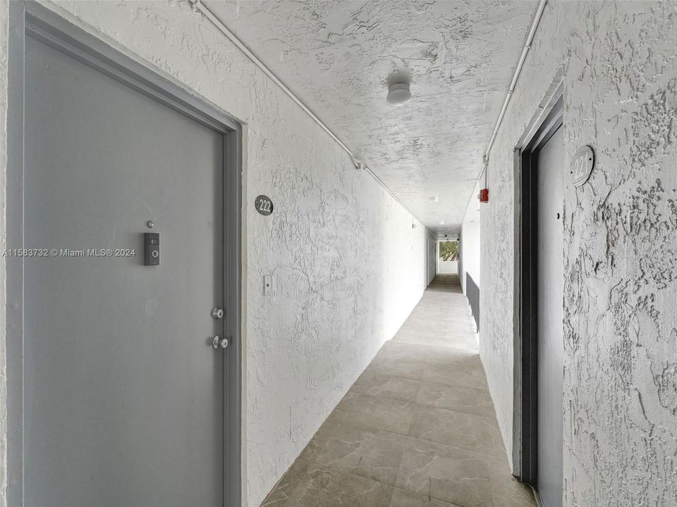 Hallway Community - Second Floor - Building and unit doors recently painted and new floor tiles have been installed