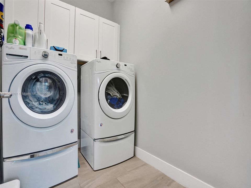 Full size washer and dryer and cabinets in the large separate laundry room