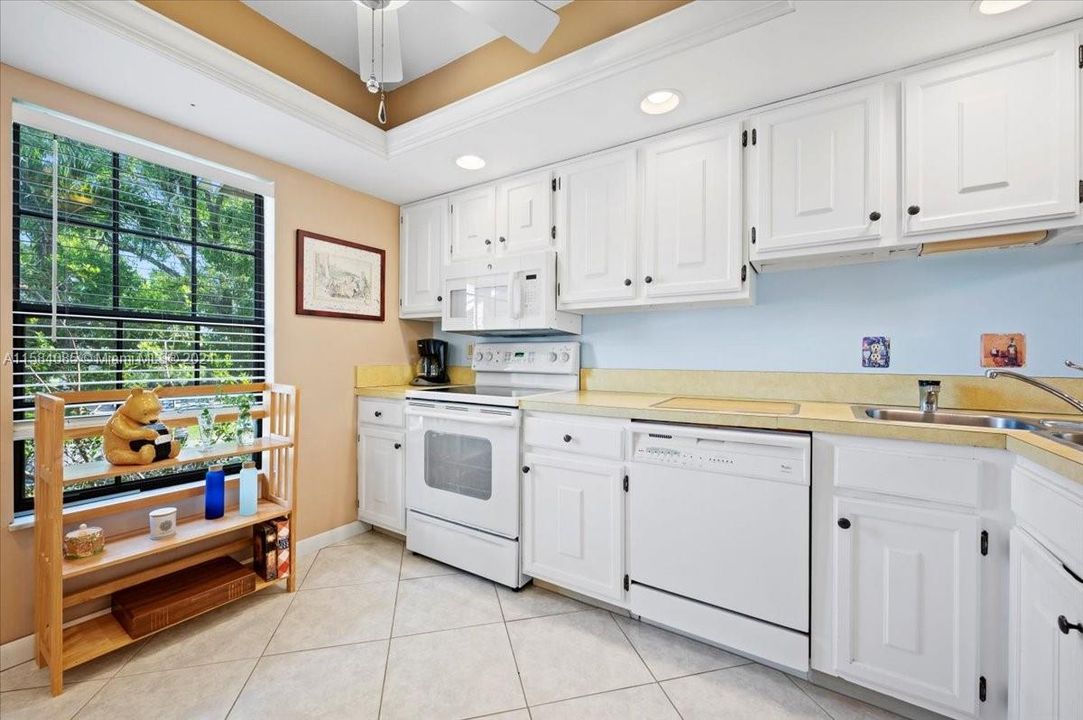 Sunny kitchen , white cabinets , pretty glass cabinets for display