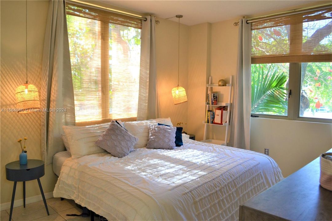 Corner bedroom is an oasis for zenful rest. Treetop views as if you're in the country yet in the middle of a tropical oasis.