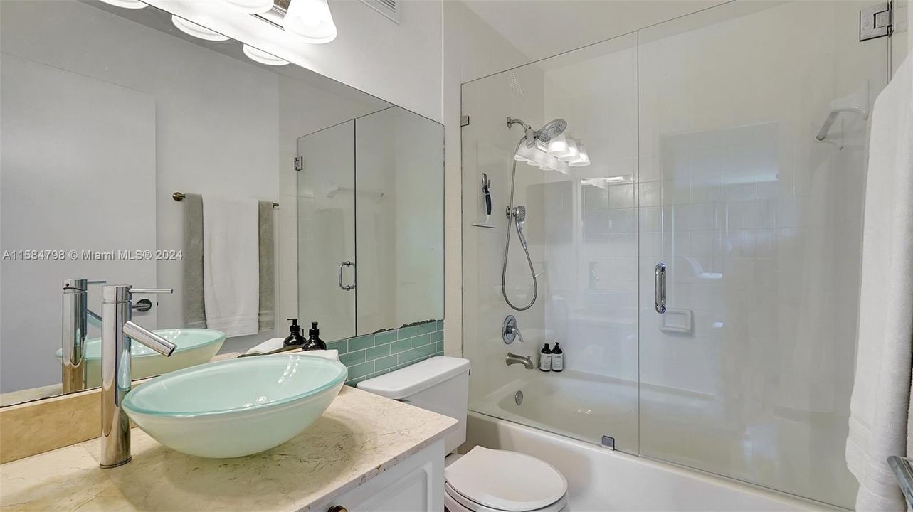 Updated bathrooms with frameless glass shower enclosures.