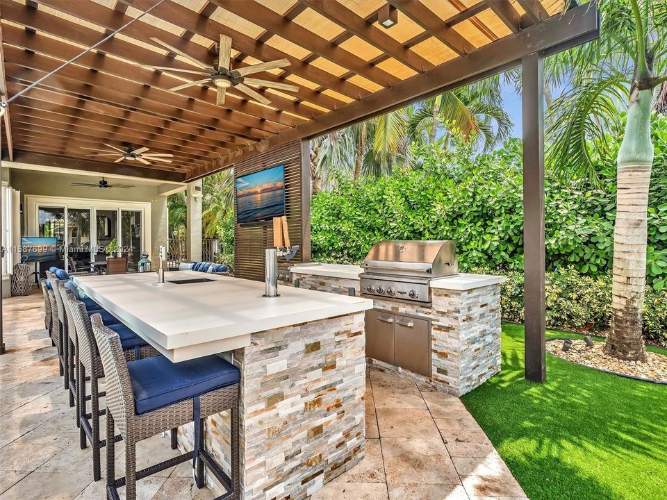 Outdoor summer kitchen with built in grill, sink, refrigerator, and 2 tap kegerator