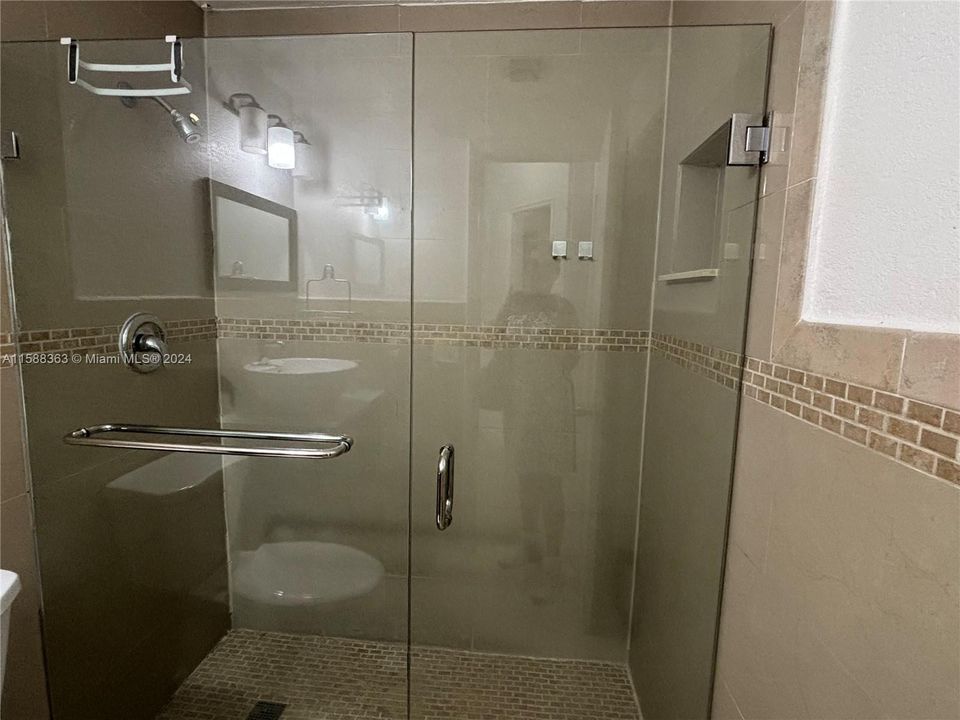 Shower with glass enclosure.