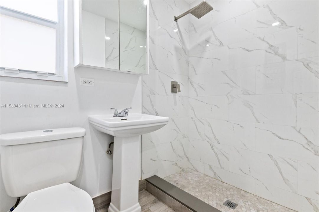 Second bathroom remodeled with light colors, granite and modern fixtures.