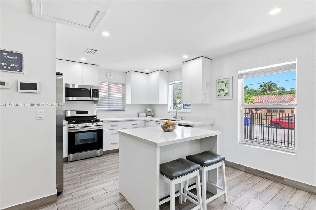 Light and bright kitchen with new appliances and center island.