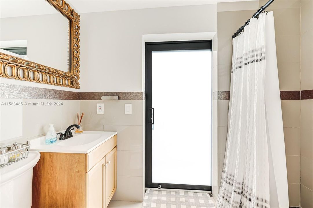 Primary bedroom ensuite bathroom opens to back patio.