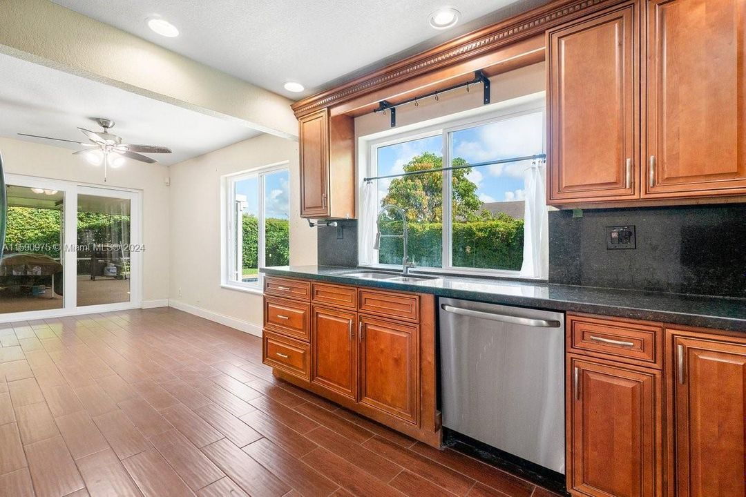 Kitchen overlooks family room, enclosed patio and sparkling pool