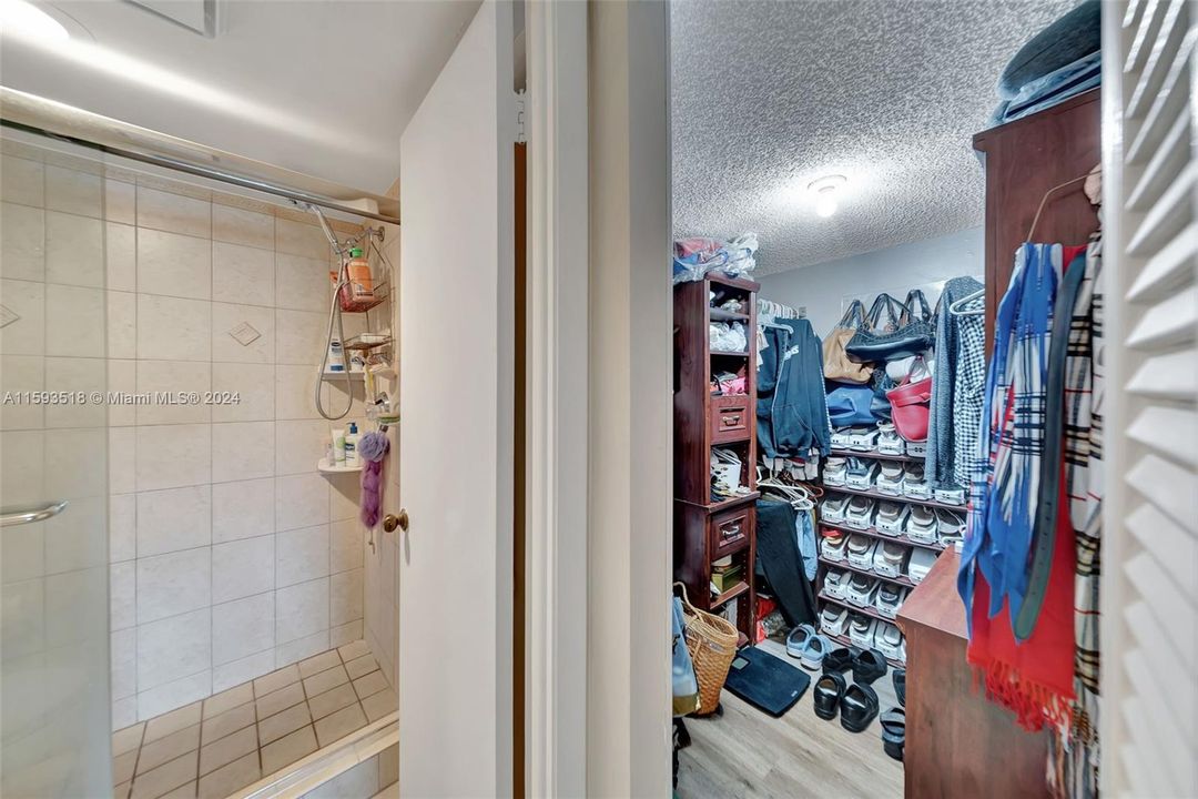 Large walk-in closet with new wood laminate floors in Primary Bedroom with adjacent bathroom