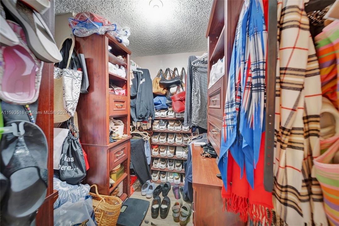 Primary Bedroom closet with custom shelving, lots of storage