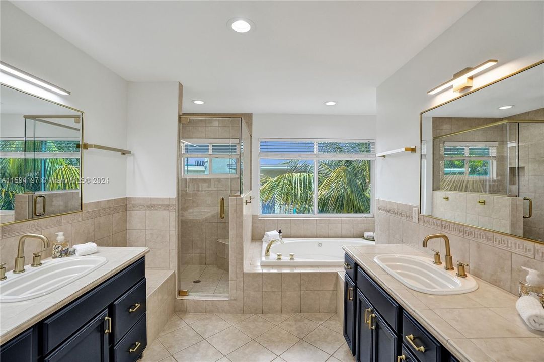 Primary bathroom with his and hers side, stand alone shower and roman tub.
