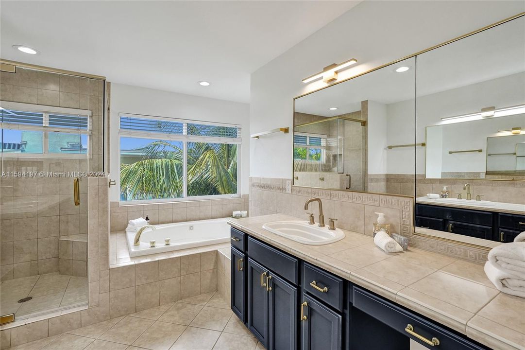 Primary bathroom with his and hers side, stand alone shower and roman tub.