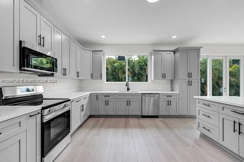 STUNNING KITCHEN W/ ENERGY SAVING FRIGIDAIRE APPLIANCES, CUSTOM CABINETS W/ QUARTZ COUNTERS, CENTR ISLAND, ALL OVER LOOKING THE GREAT ROOM W. VIEWS TO THE OUTSIDE FRONT & BACK